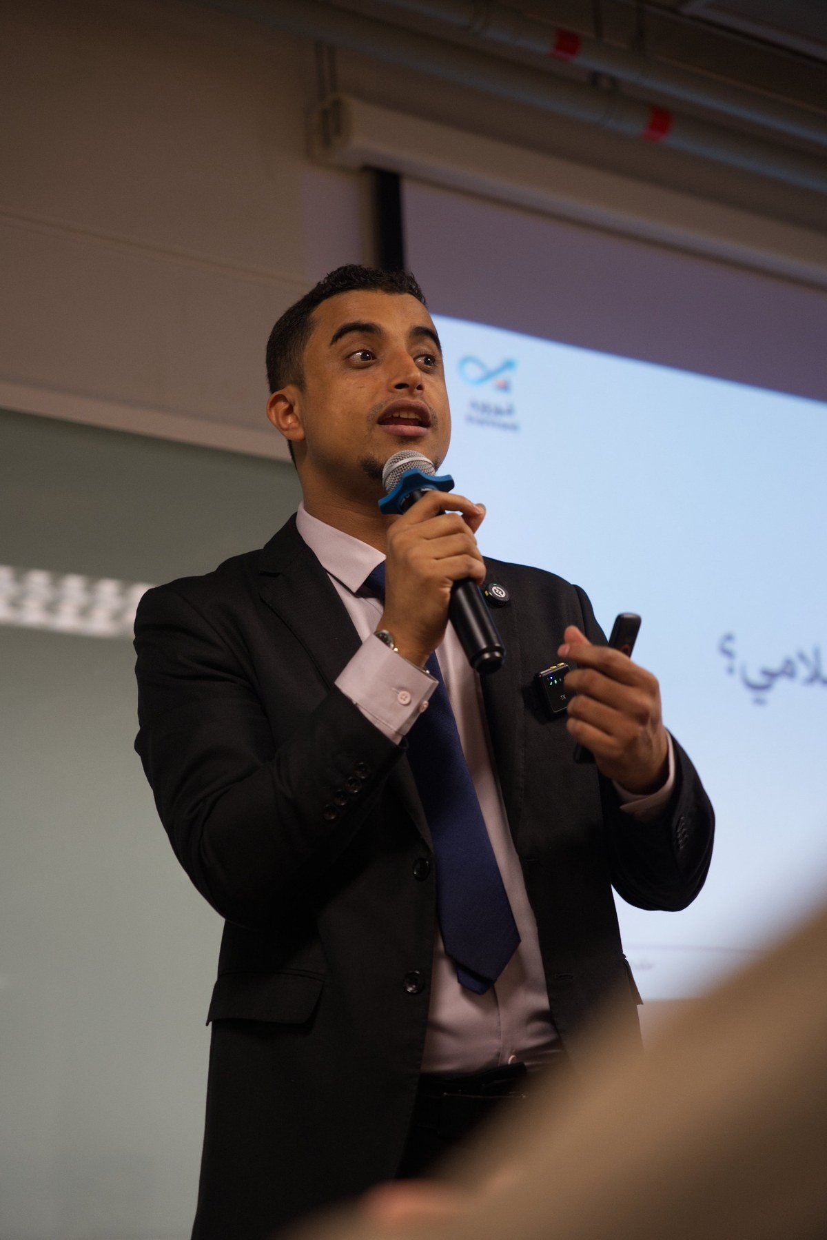 Salman Alabd speaking during a professional presentation.